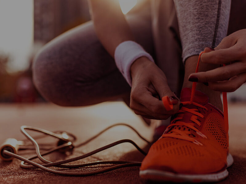 Female runner tying her shoes and preparing for a jogging.